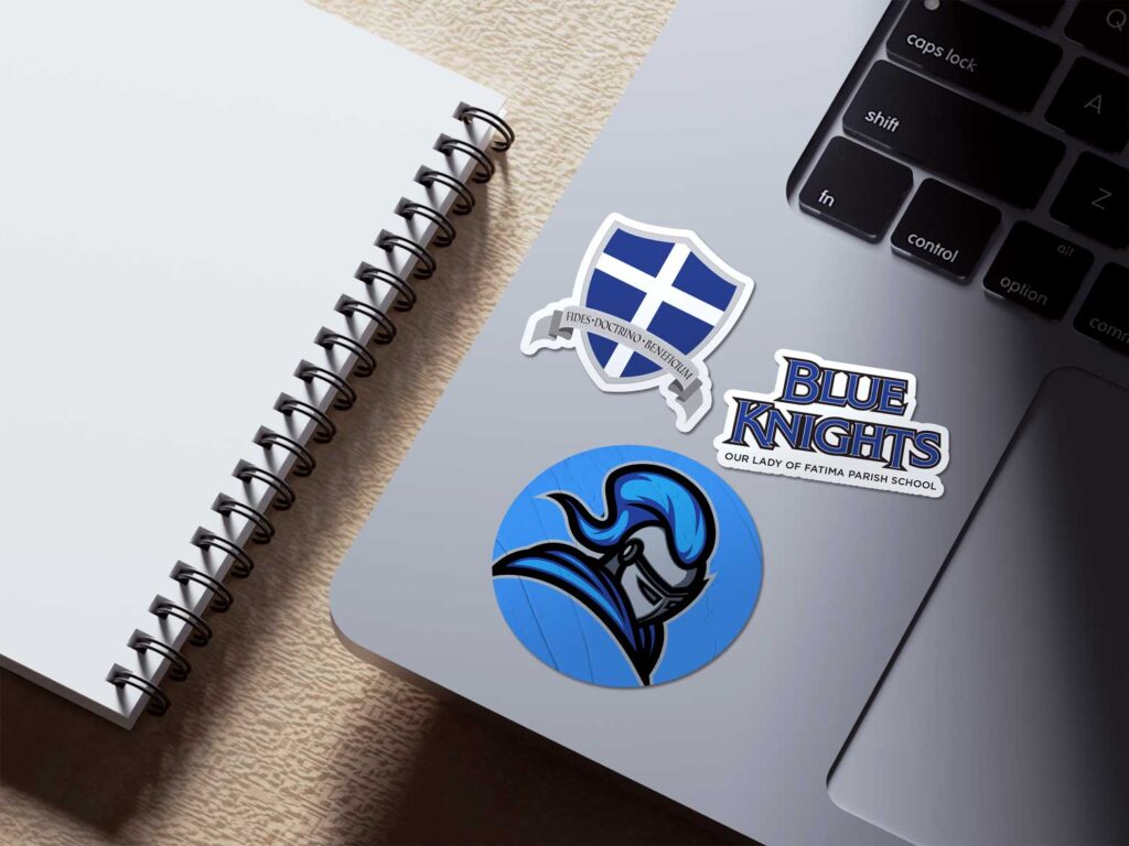 The Our Lady of Fatima mascot, heraldic shield, and Blue Knights wordmarks were rendered as stickers adhered to a laptop.